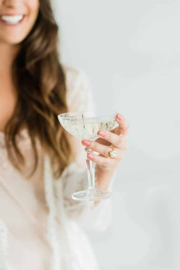 Braut beim Getting Ready mit einem Champagner Glas in der Hand