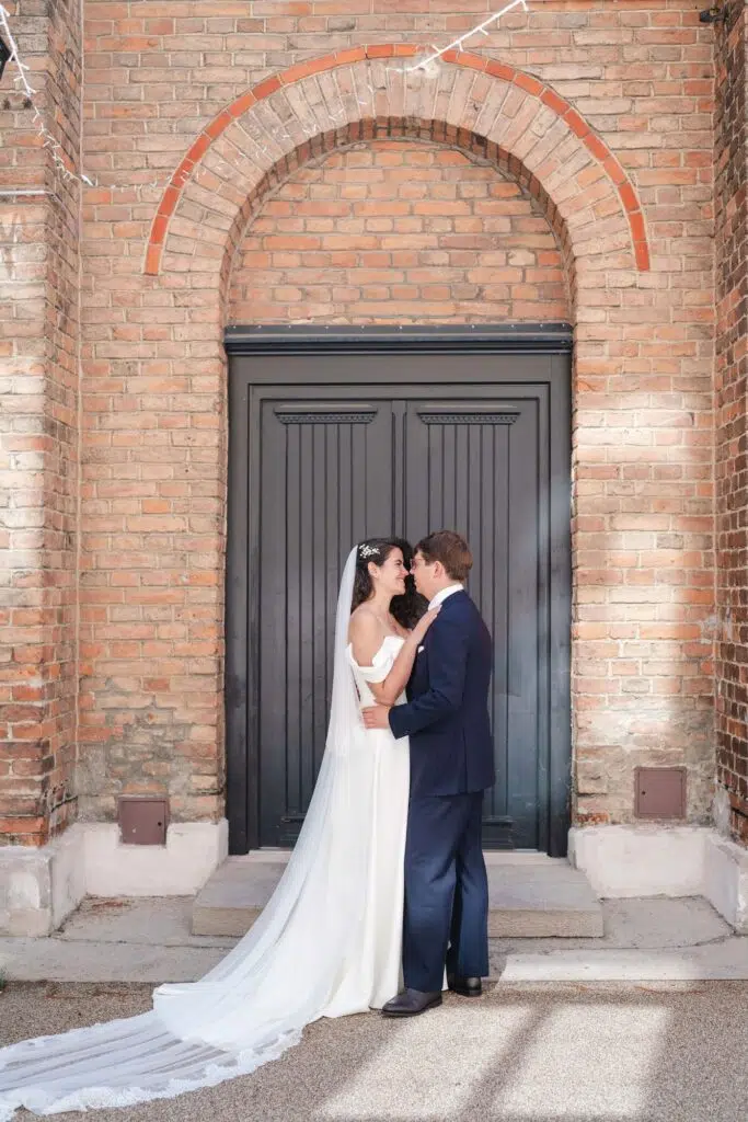 Hochzeit im Gabrium: Brautpaar vor dem Rundbogenportal der Ziegelfassade